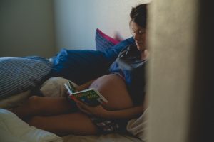 Pregnant mum reading to her tummy.